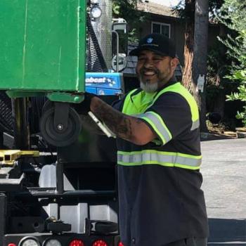 employee loading a green bin