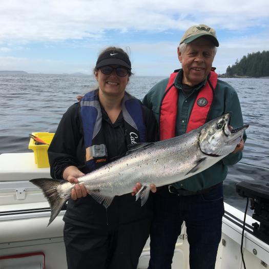two people holding salmon